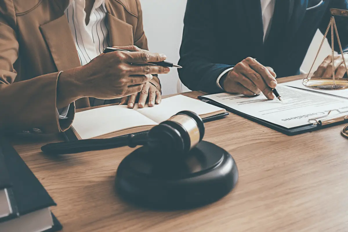 Scooter accident attorneys go over a case with their client while sitting at a table.