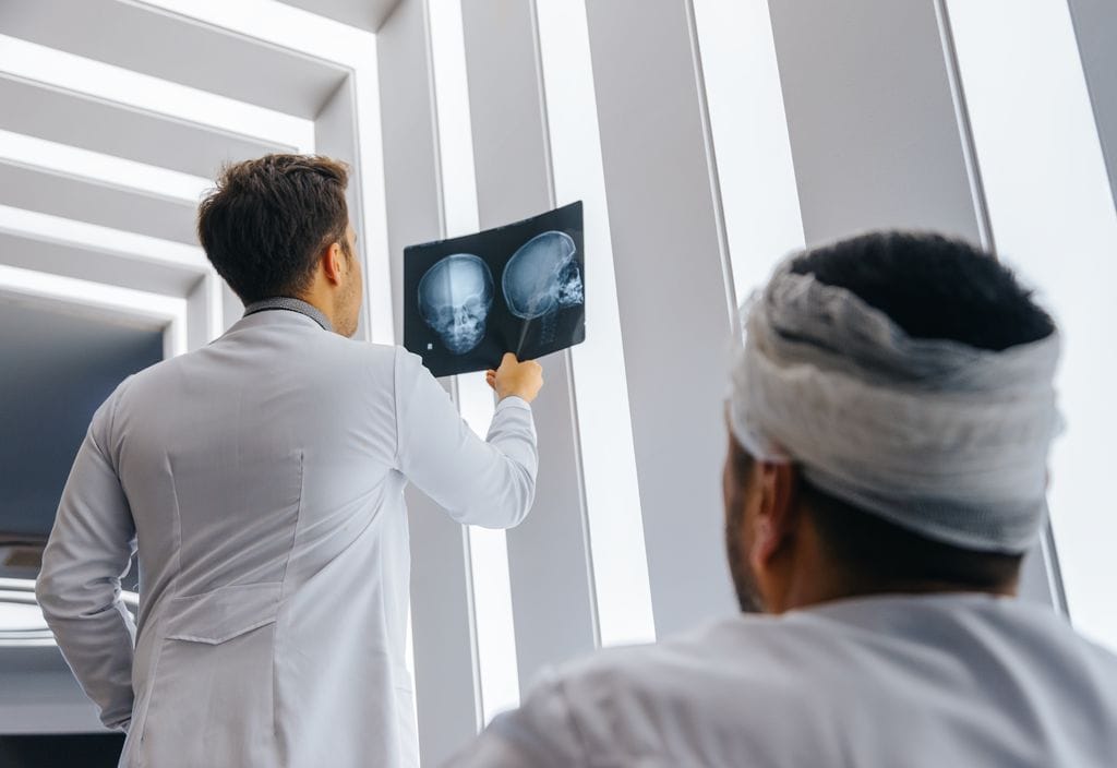 A doctor reviews an x-ray of a car accident victim that sustained head and brain injuries.