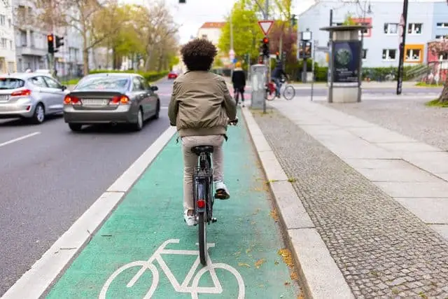 A man rides his bicycle in the bike lane on his commute to work.