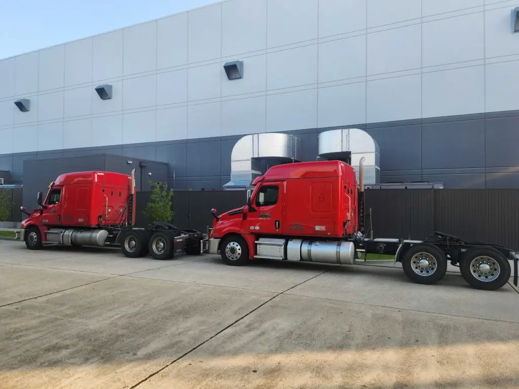 Two bobtail truck cabs parked on the street.
