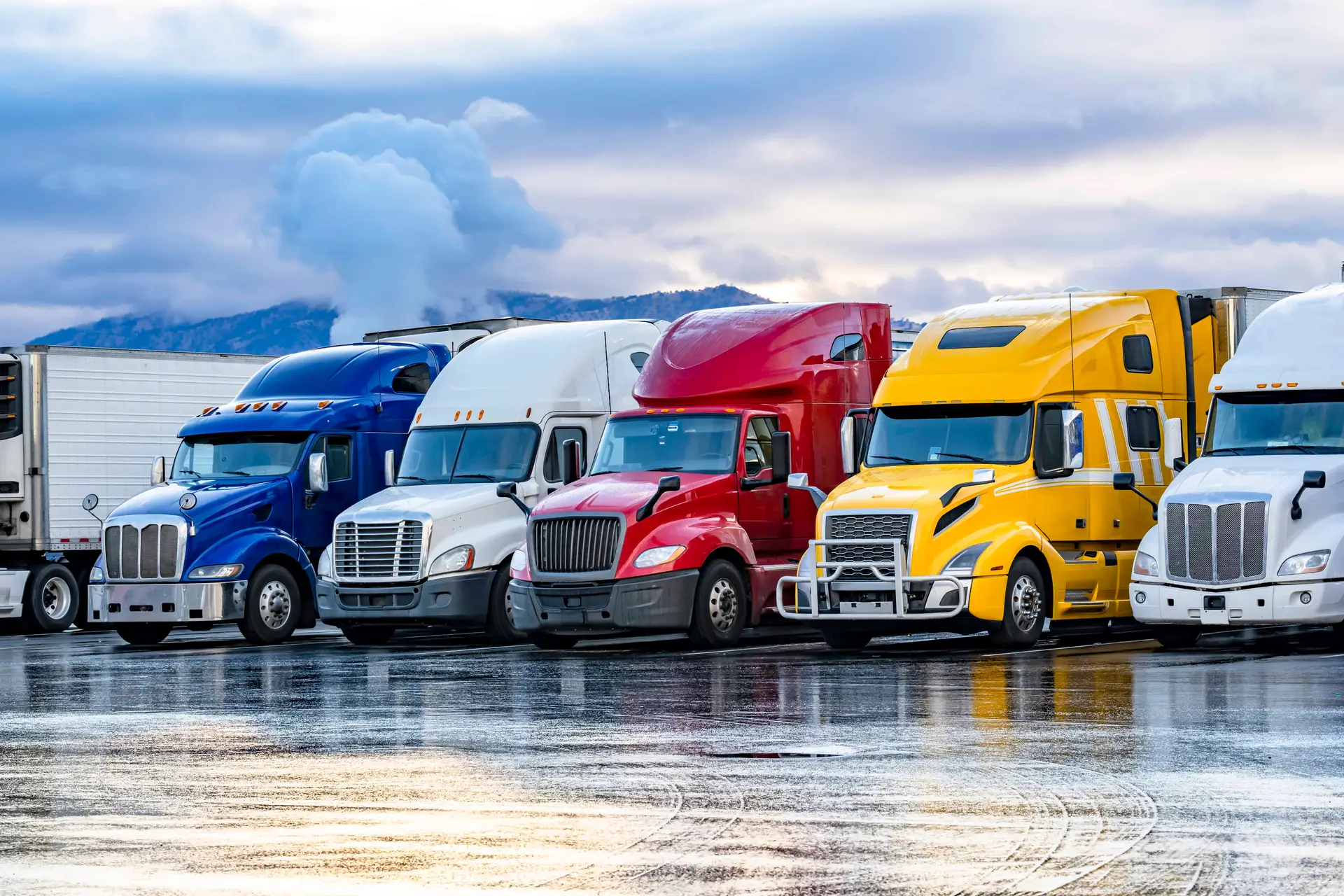 A row of colorful semis parked in a row on a cold winter day.