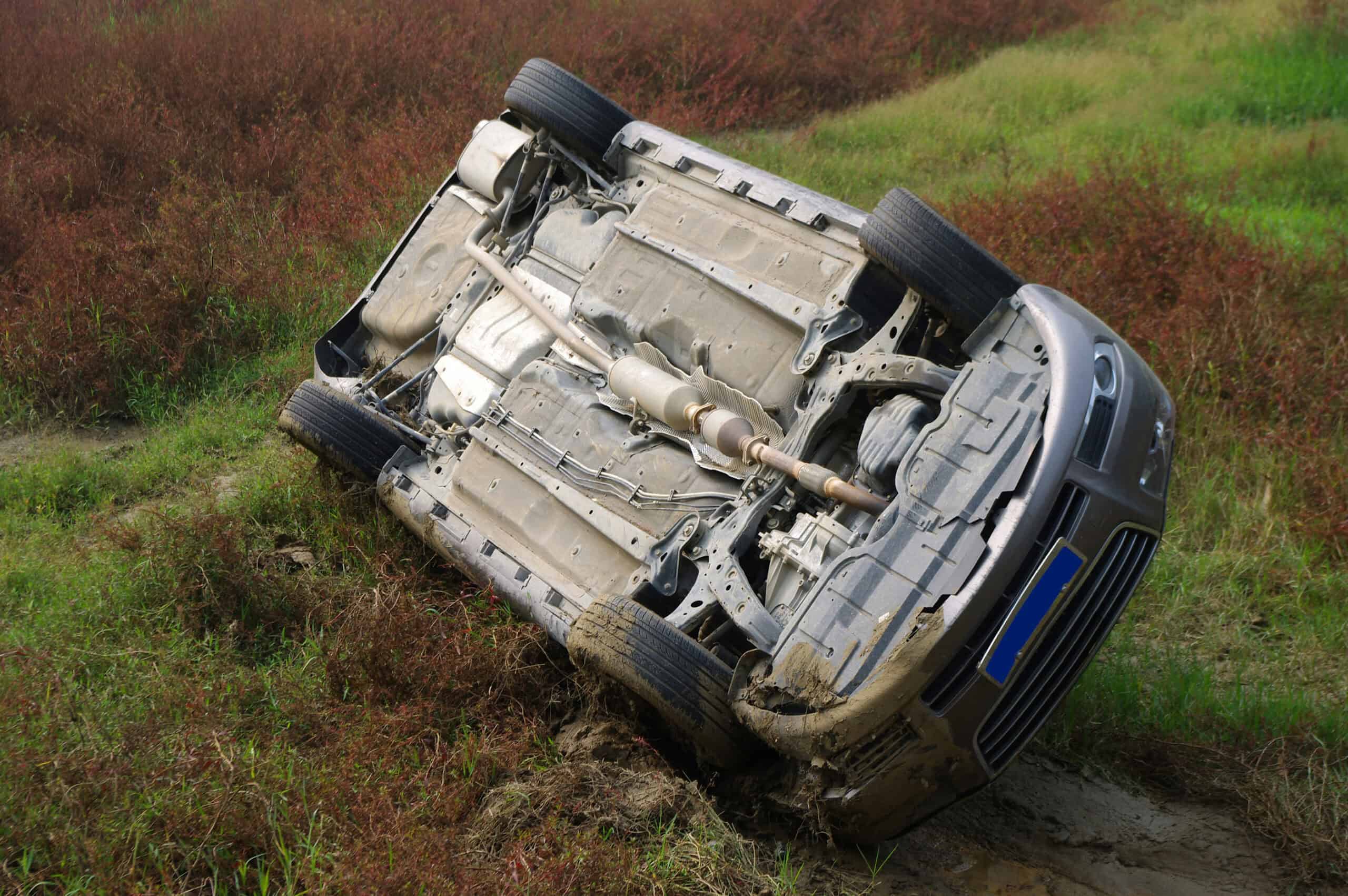 An overturned car after it rolled down an embankment off the side of the road.
