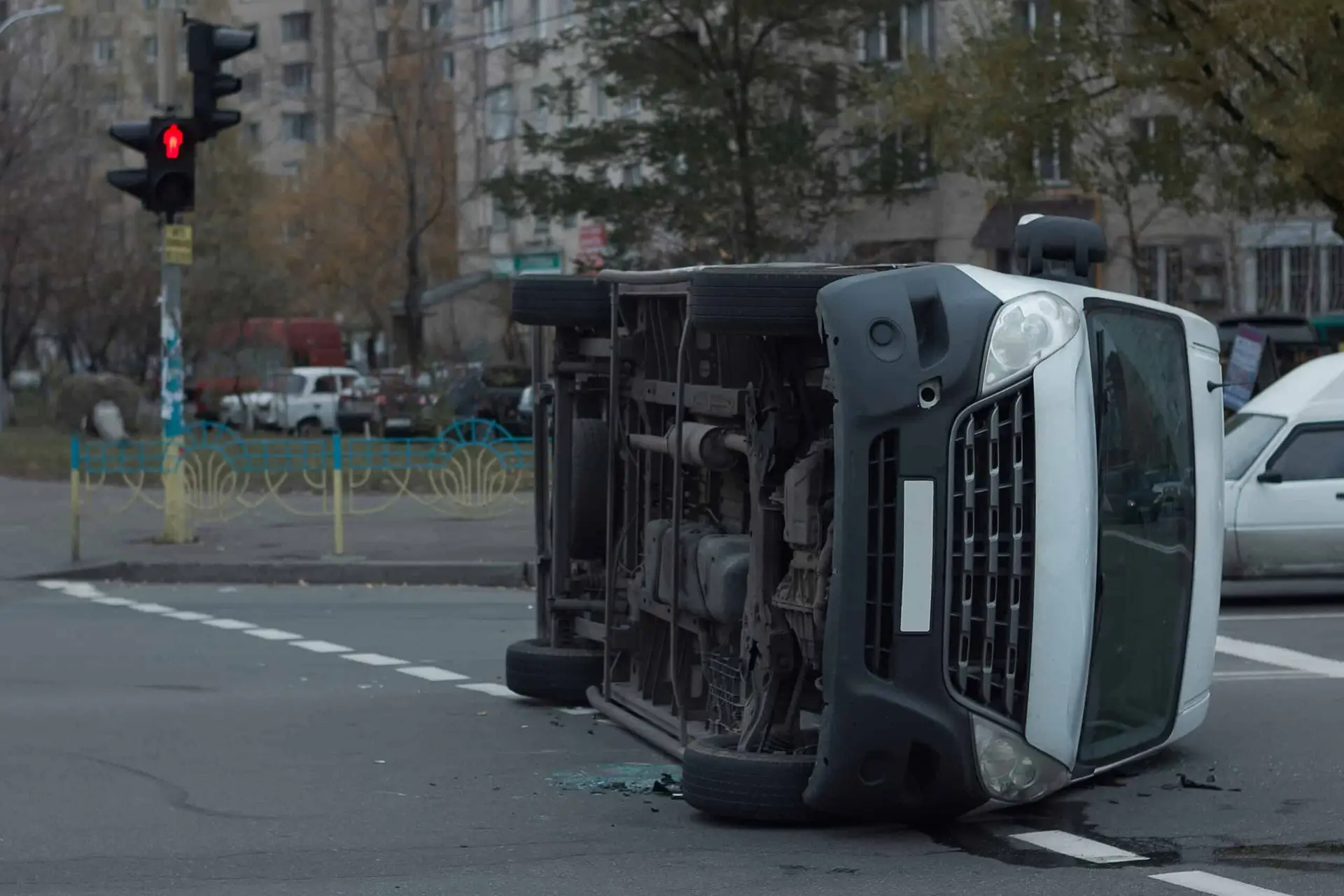 A white van is rolled over on its side after an accident at an intersection.