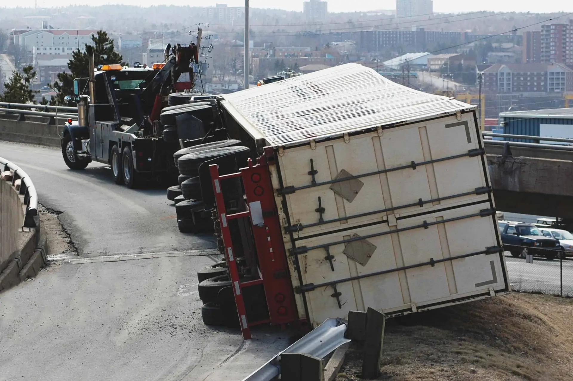 A tow truck assists an overturned semi after a rollover truck accident.