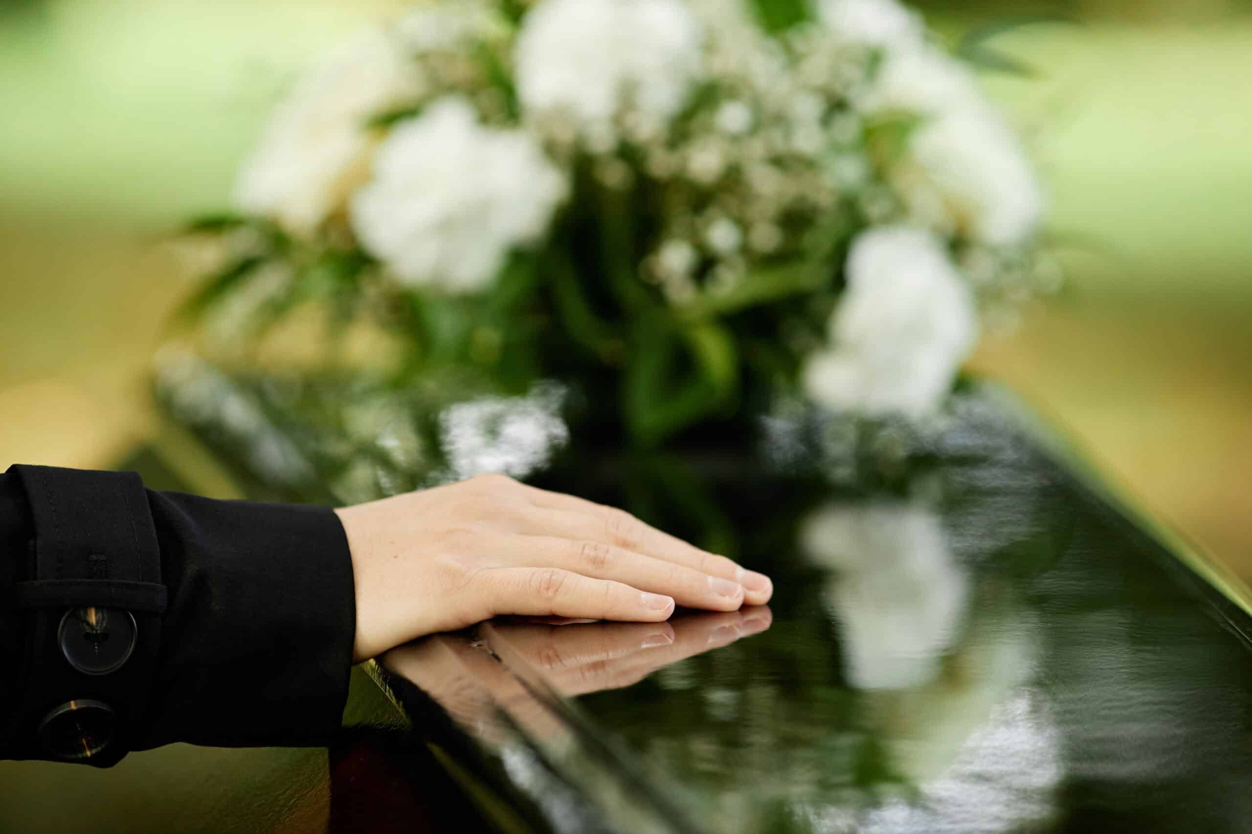 A woman pays her final respects to a loved one at a funeral.