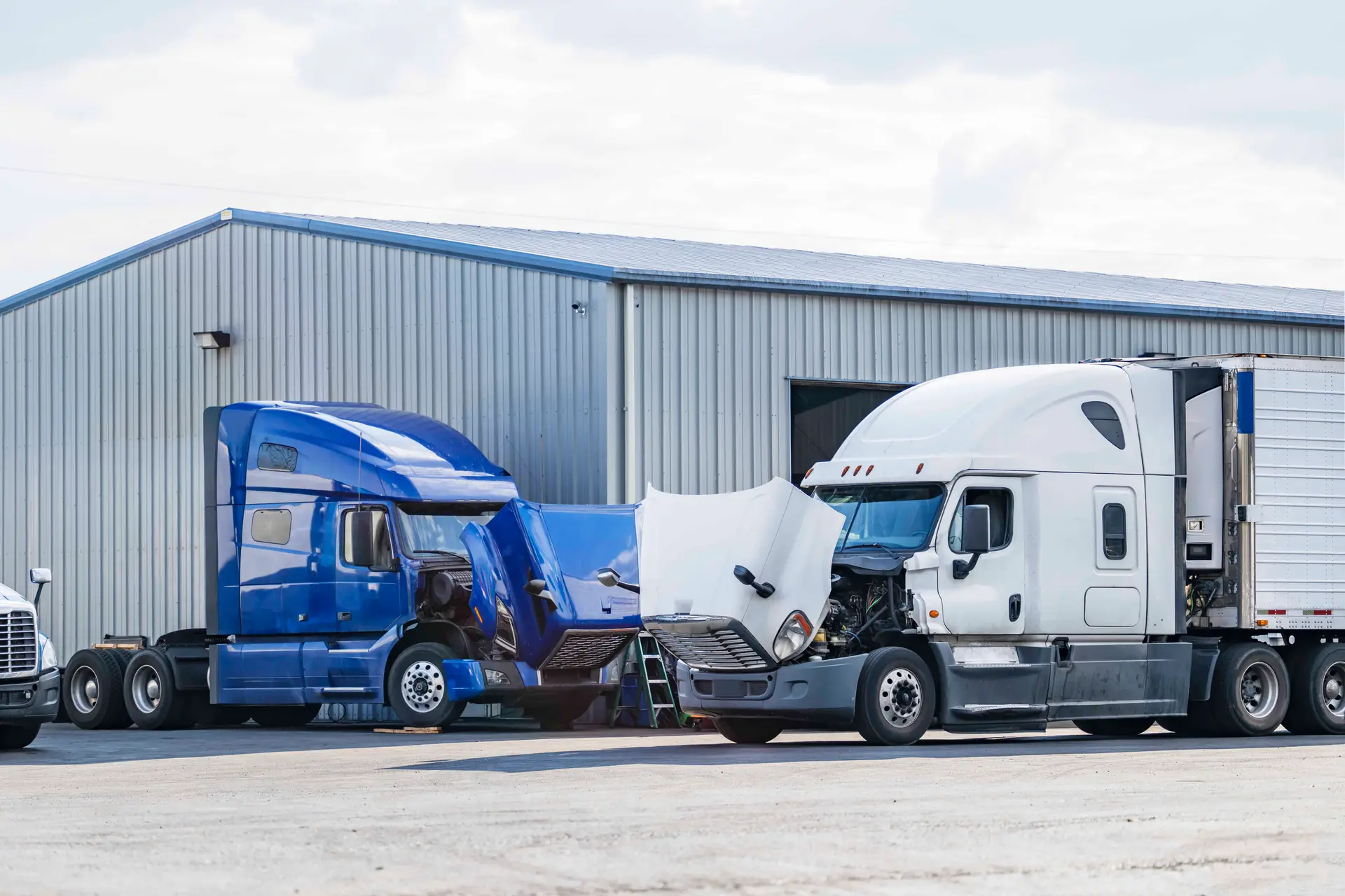 Trucks receiving mechanical inspections to satisfy commercial trucking insurance requirements.