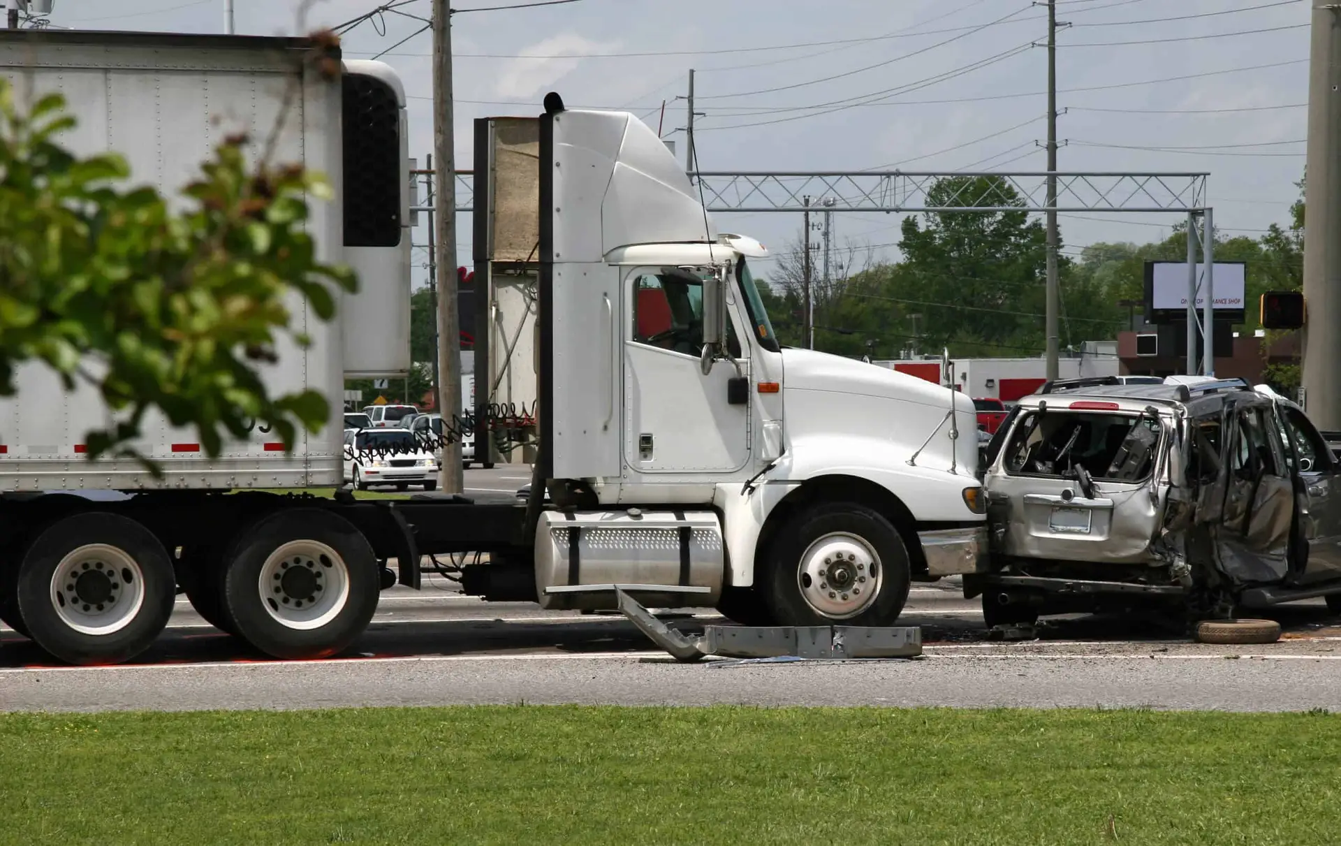The scene of an accident where a semi-truck rear-ended a minivan, causing severe damage to the van and injuries to the passengers inside.