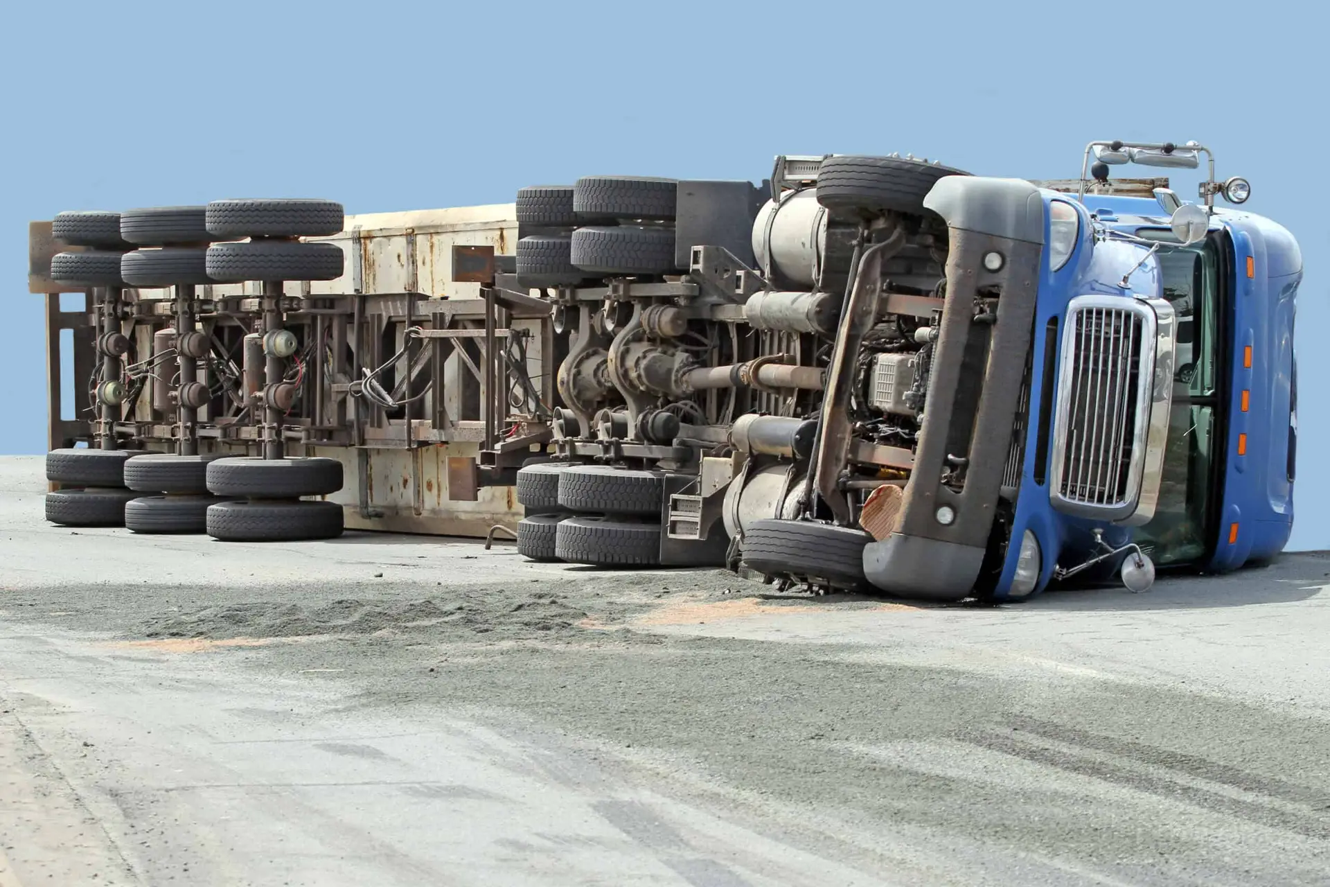 a blue truck rolled over onto its side.