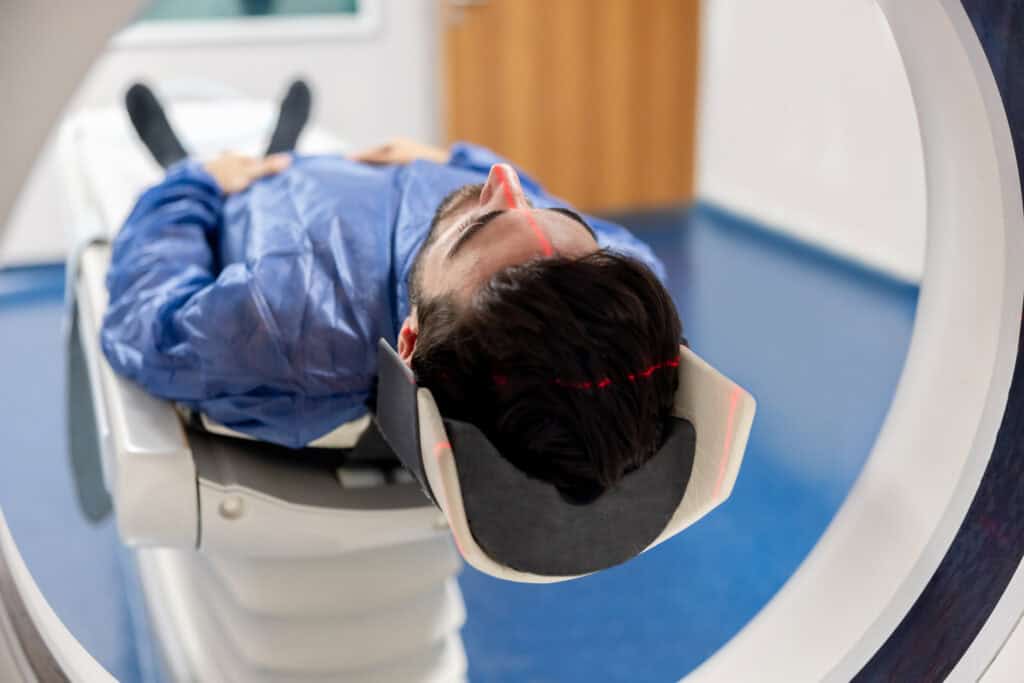 A man is loaded into a CT machine to take a brain scan.
