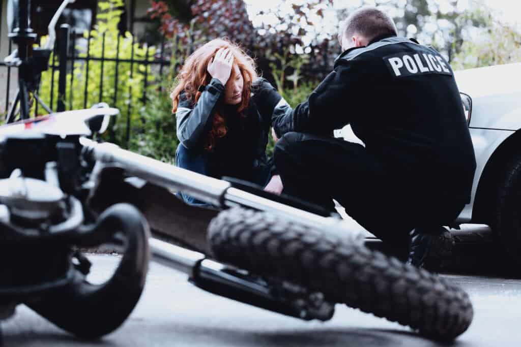 A man holds his forehead after sustaining a brain injury after a motorcycle accident.