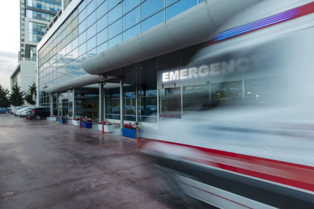 An ambulance speeds up to the entrance of an emergency room with a victim injured in an accident.