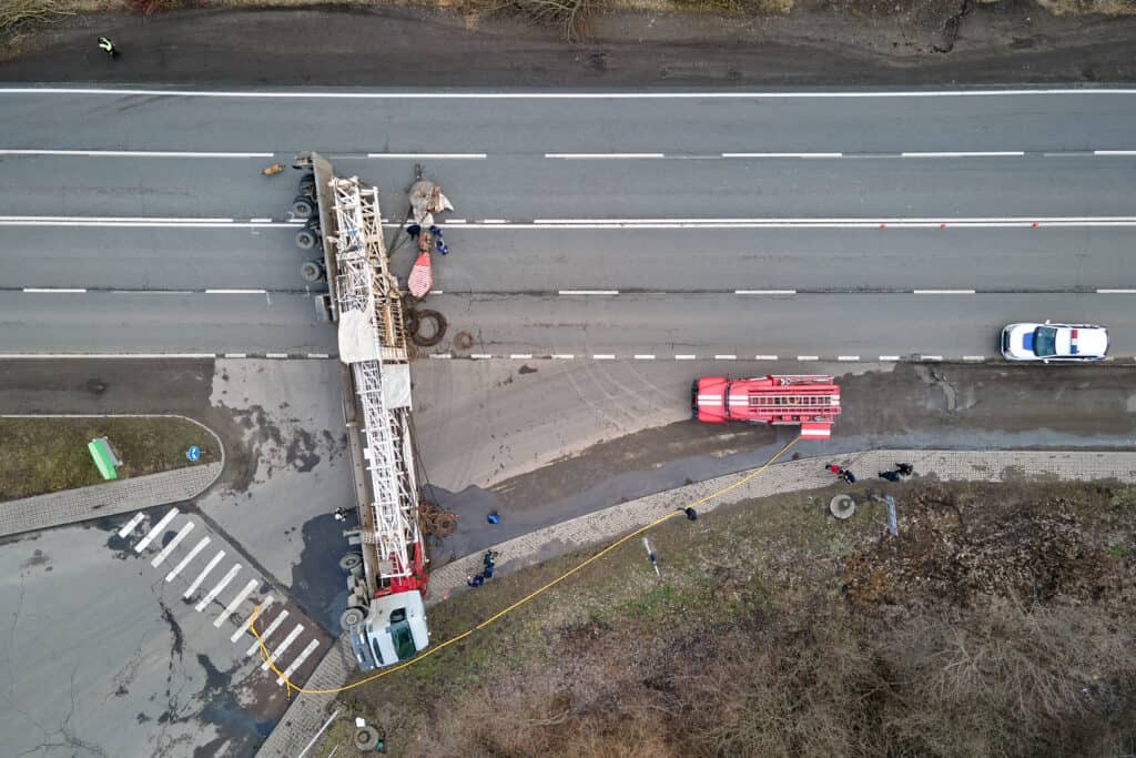 Aerial view of road accident with overturned truck blocking traffic.