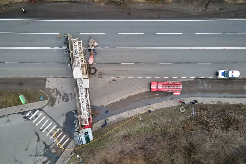 Aerial view of road accident with overturned truck blocking traffic.