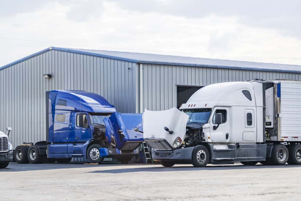 Semi-trucks parked in a parking lot awaiting inspection.