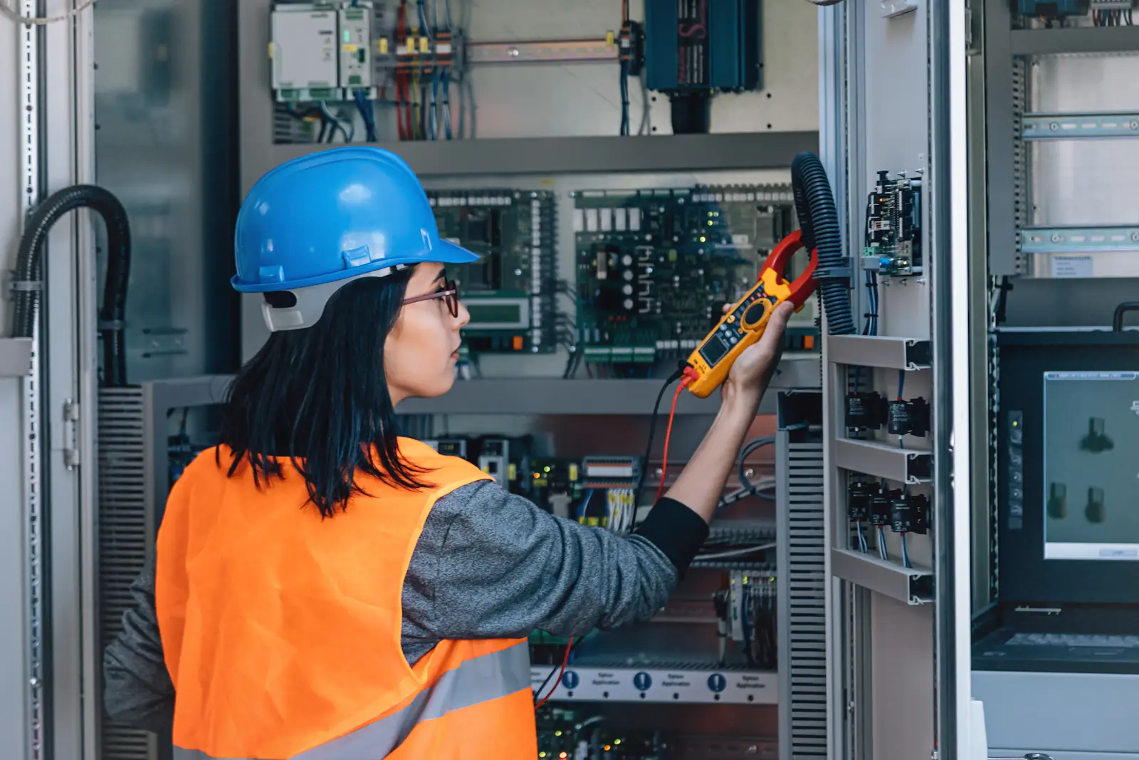 woman working on an electrical box with construction gear on