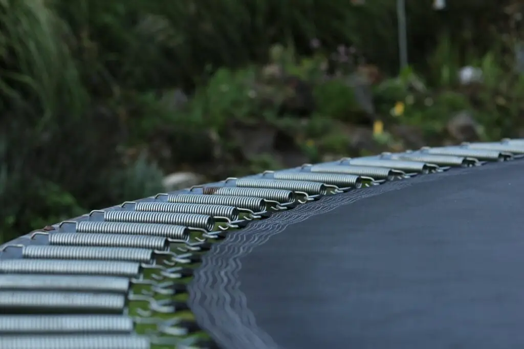 The springs that connect a trampoline mat to the base structure.