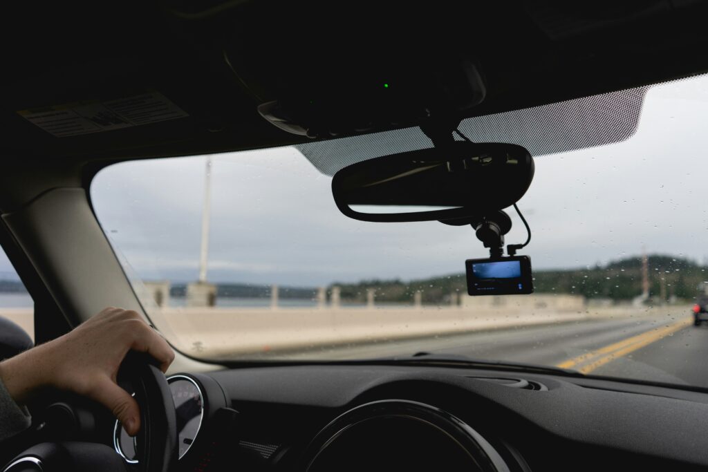A car travels down the road with a dashcam recording the trip.