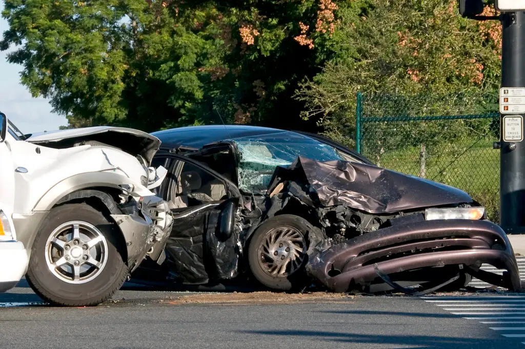 Two cars with excessive damage in an intersection after one of the vehicles ran a traffic signal while speeding.