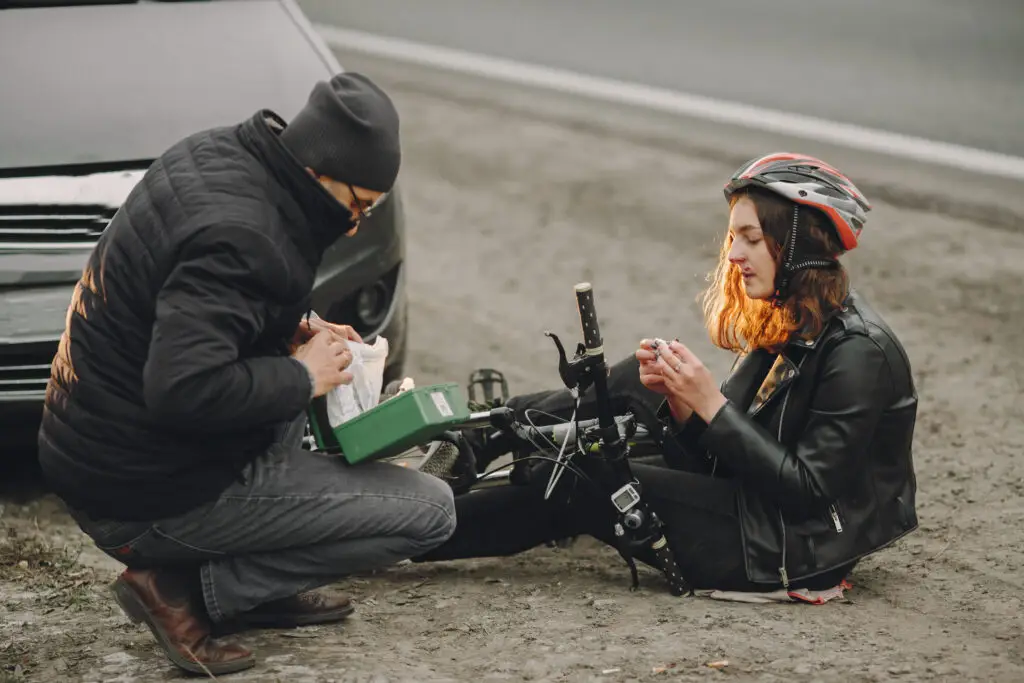 A woman receives first aid after an accident on her electric bicycle.