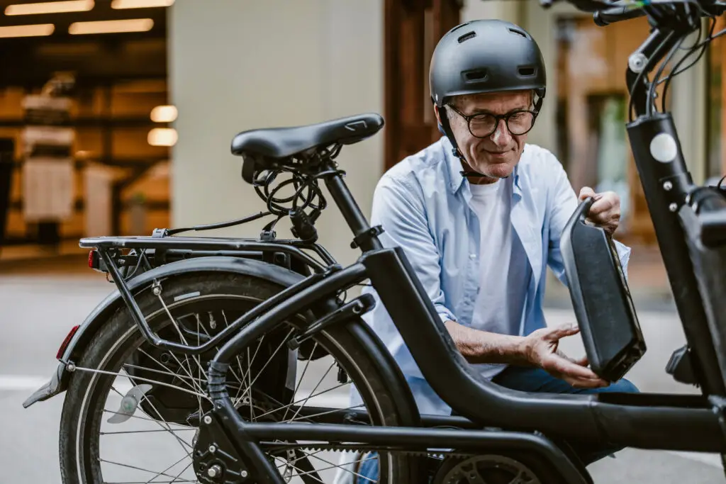 A man inspects the battery on his e-bike before he takes it out for a ride. 